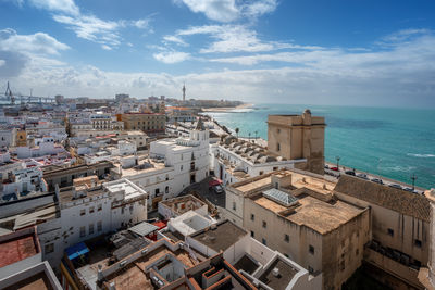 High angle view of townscape by sea against sky