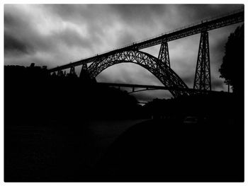 Low angle view of bridge against cloudy sky