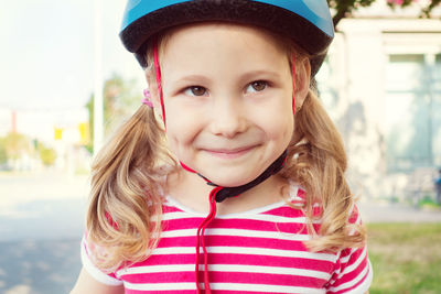 Close-up of smiling girl wearing cycling helmet