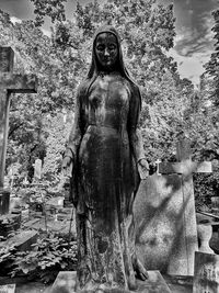 Statue of buddha against trees and buildings