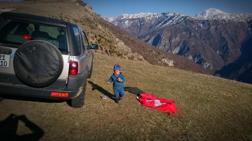 Rear view of man on car against mountain range