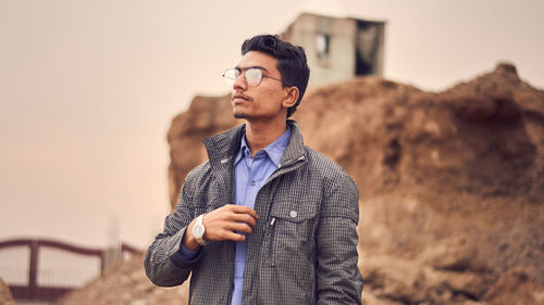 Low angle view of man wearing eyeglasses looking away