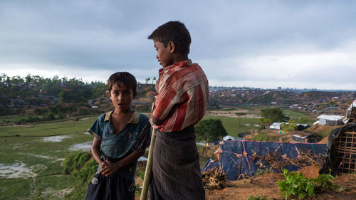 Young couple standing on mountain against sky