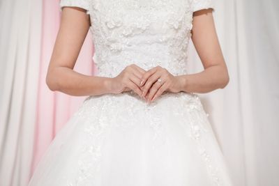 Close-up of woman hand holding white dress