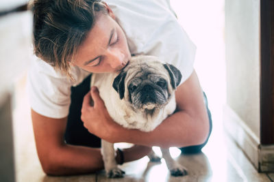 Boy kissing dog at home