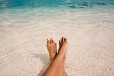 Low section of woman relaxing in sea