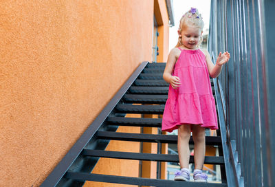 Rear view of girl standing on staircase