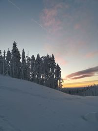 Scenic view of snow covered landscape against sky during sunset