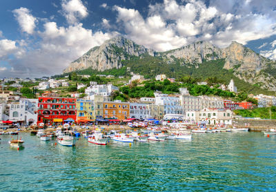 Boats moored in harbor against buildings in city