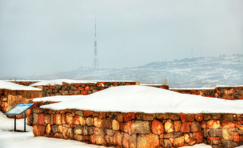 Snow covered buildings against sky