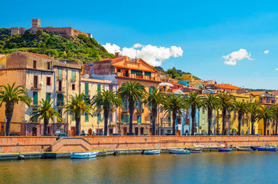 Houses by river against sky