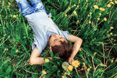 High angle view of boy lying on grassy field