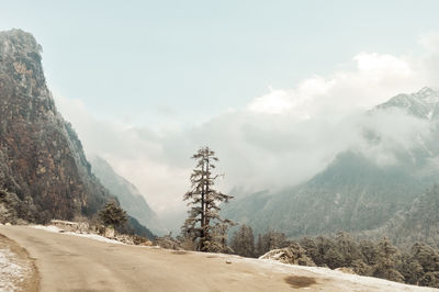 Road by mountains against sky