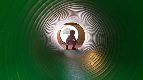 Portrait of boy seen through green tube