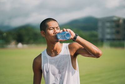 Young woman drinking water from bottle