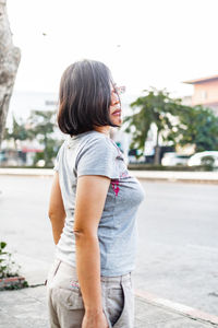 Side view of woman looking away in city