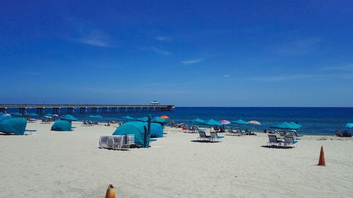 Scenic view of beach against blue sky