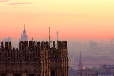 Skyscrapers in city against sky during sunset