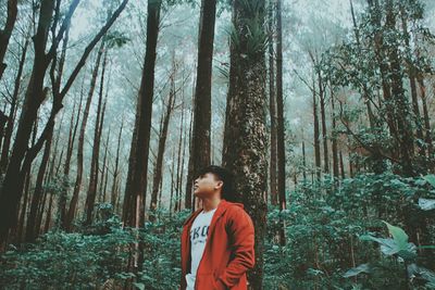 Full length of teenage girl standing in forest
