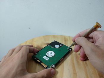 Midsection of person holding camera on table