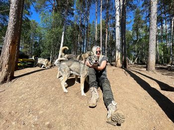 Women and dogs against trees