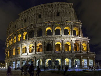 Group of people in front of historical building at night