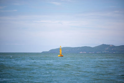 Sailboat sailing on sea against sky