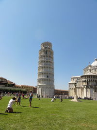 Group of people in front of built structure against clear sky