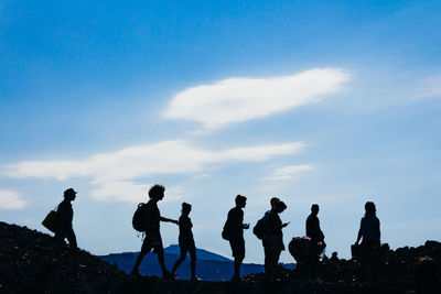 Low angle view of people against blue sky