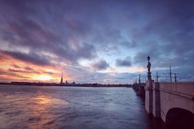 Scenic view of sea against cloudy sky at sunset