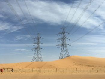 Electricity pylon on land against sky