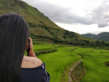 Rear view of woman on landscape against sky