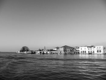 River in front of houses against clear sky