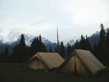 Tent by snowcapped mountain against sky