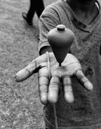 Midsection of boy showing spinning top on hand