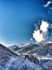 Scenic view of snowcapped mountains against blue sky