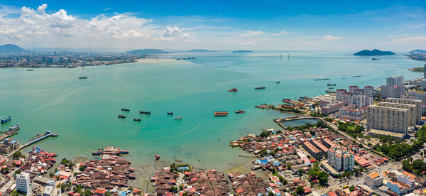 High angle view of buildings by sea against sky