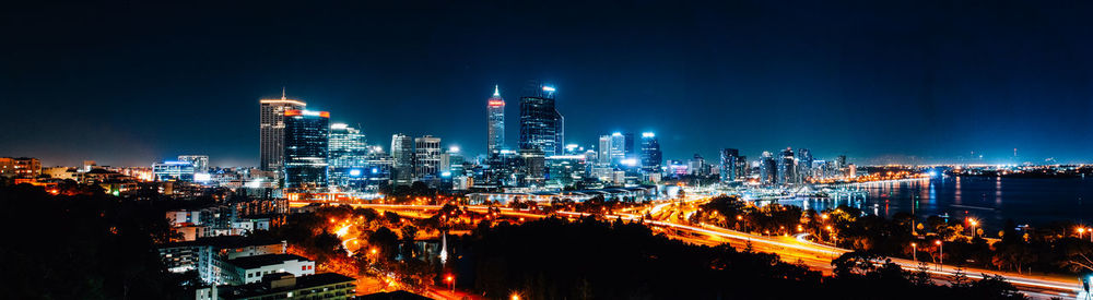 Illuminated buildings in city against sky at night