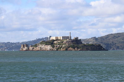 Buildings by sea against sky