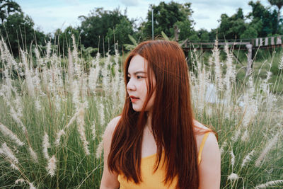 Portrait of young woman standing against lake