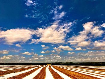 Road amidst landscape against blue sky