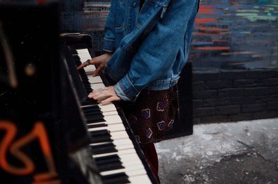 Midsection of man playing piano