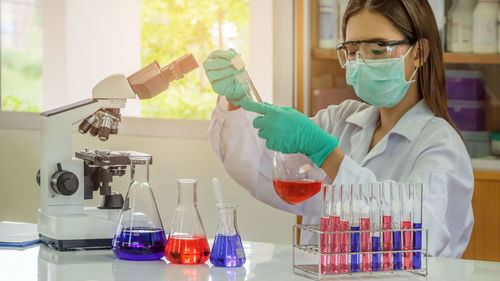 Female scientist examining chemical in laboratory