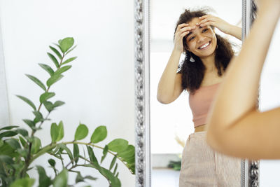 Portrait of young woman using mobile phone at home