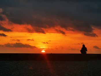 Scenic view of sea against orange sky