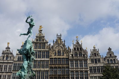 Low angle view of statue of building against cloudy sky