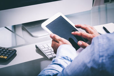 Low section of person touching hand using mobile phone