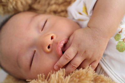 Close-up of cute baby boy sleeping on bed
