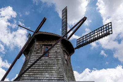 Old vintage wind turbine on blue sky background.