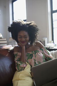 Portrait of woman using phone while sitting on table